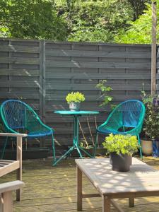 2 chaises bleues et une table sur une terrasse dans l'établissement City Centre Escape with Private Garden, à Édimbourg