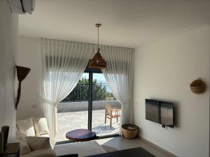 a living room with a large window with a patio at פשוט גולן in Bruchim Qela' Alon