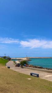 Un parque con bancos junto al agua y una playa. en Dar dyafa, en Larache