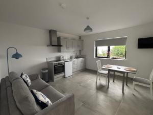 a living room with a couch and a table at Coastal Charm in Carnlough
