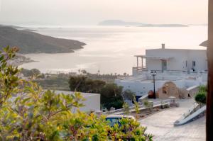 a view of a white building with the ocean in the background at Skopelitis Village in Katapola