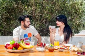 a man and a woman sitting at a table with fruit at Skopelitis Village in Katapola