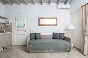 a bedroom with a bed and a mirror on the wall at Skopelitis Village in Katapola