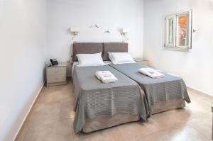 a bedroom with a large bed with two towels on it at Skopelitis Village in Katapola