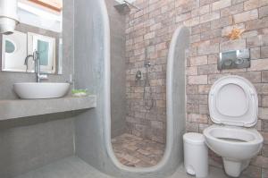 a bathroom with a shower with a toilet and a sink at Skopelitis Village in Katapola