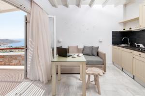 a living room with a couch and a table with a laptop at Skopelitis Village in Katapola
