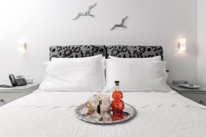 a tray with a bottle and three glasses on a bed at Skopelitis Village in Katapola