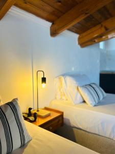 a bedroom with two beds and a lamp on a table at Paradises's Nest in Agios Georgios