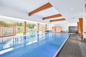 an indoor swimming pool with blue tiles in a house at House 6 in Looe