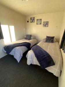 a room with two beds in a room at Waitomo Farmstay - Fantail Cabin 6 in Waitomo Caves