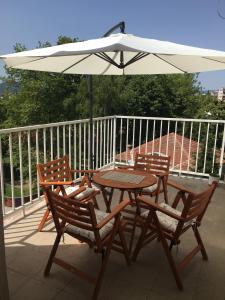a table and two chairs and an umbrella on a deck at S&N Apartment in Ohrid