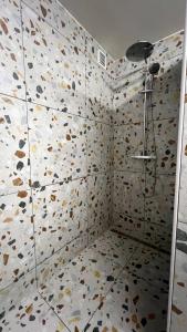 a bathroom with a shower with a tiled wall at It Wûnder in Oude Bildtzijl