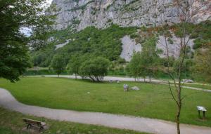 a park with a bench and a mountain in the background at Ladino House in San Lorenzo in Banale