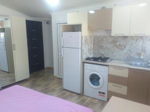 a kitchen with a white refrigerator and a washing machine at Orkide in Sheki