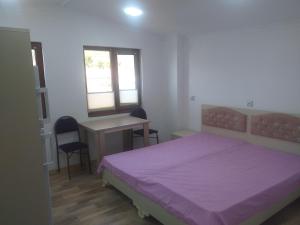 a bedroom with a bed and a desk and a table at Orkide in Sheki