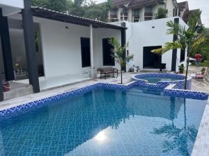 a large swimming pool with blue tiles in a house at CasaView Island Marang in Marang
