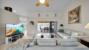 a living room with a couch and a flat screen tv at Casa de La Vista – Pool Spa with lakefront view in Cape Coral