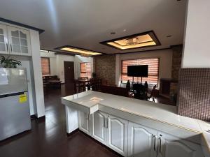 a kitchen with a refrigerator and a living room at MG Holiday Home Tagaytay in Tagaytay