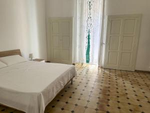 ein Schlafzimmer mit einem Bett und einem gefliesten Boden in der Unterkunft Dimora Immacolata in Castellana Grotte