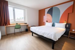 una camera d'albergo con un letto, una scrivania e una finestra di B&B HOTEL Mons Gare a Mons