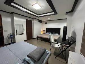 a bedroom with a bed and a desk with a computer at MG Holiday Home Tagaytay in Tagaytay
