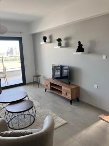 ein Wohnzimmer mit Fernseher und Tisch und Stühlen in der Unterkunft Sokrates in Larnaka + 6 Fotos