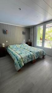 een slaapkamer met een bed met een dekbed erop bij Maison au bord de l'eau avec Jacuzzi in Millau