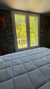 een groot bed in een kamer met 2 ramen bij Maison au bord de l'eau avec Jacuzzi in Millau