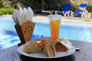 a plate of sandwiches and a drink next to a pool at Vico hotel in Nusa Dua