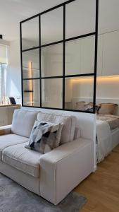 a living room with a couch and a large mirror at Algirdo Sunlight Studio in Vilnius