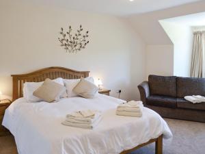 ein Schlafzimmer mit einem Bett mit Handtüchern darauf in der Unterkunft March Cottage in Glenrossal