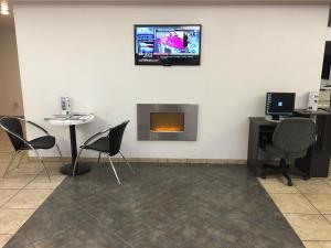 a room with a fireplace and a tv on the wall at Motel 6-Globe, AZ in Globe