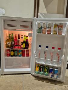 an open refrigerator filled with drinks and drinks at Striped Horse Guest House - Kenilworth Upper in Cape Town
