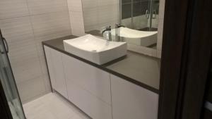 a white bathroom with a sink and a mirror at Mieszkanie Tarnów in Tarnów +7 photos