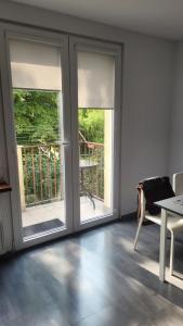 a room with two windows and a table and a balcony at Mieszkanie Tarnów in Tarnów