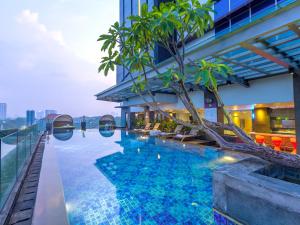 a hotel swimming pool with a view of the city at The Southern Hotel Surabaya in Surabaya