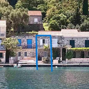 a house with blue poles in the water at Sunny Apartment Octopus in Prožura