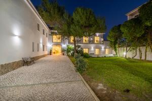 a building with a bench in front of a yard at Silver Seahorse Garden Retreat in Peniche +31 photos