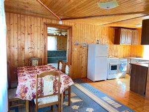a kitchen with a table and a white refrigerator at Три смерічки in Beloberëzka
