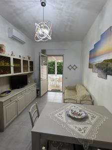 a kitchen and living room with a table and chairs at Podilimbo - Ilios e Thalassa in Paestum +35 photos