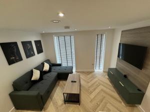 Una sala de estar con un sofá y un televisor de pantalla plana. en New 1 Bedroom Apartment Near Sheffield United Football Club, WiFi, Parking & Much More, en Sheffield