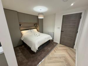 1 dormitorio con 1 cama con sábanas blancas y puerta en New 1 Bedroom Apartment Near Sheffield United Football Club, WiFi, Parking & Much More, en Sheffield