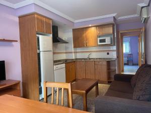 a kitchen and living room with a couch and a table at Apartamentos Villa de Ainsa in Aínsa