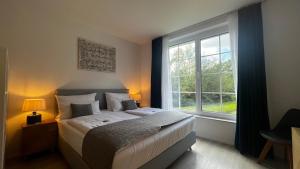 Blue Riverside Apartments في بلاوشتاين: غرفة نوم بها سرير ونافذة كبيرة