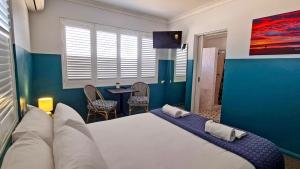 a bedroom with a large bed and a table at Sawtell Hotel in Sawtell +27 photos