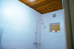 ein weißes Bad mit einer Dusche und einem Fenster in der Unterkunft Garden Villa 5BR Home Near Road,Nature and City Life in Arusha