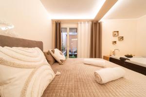 een slaapkamer met een groot bed met handdoeken erop bij Desiree Luxury House- vasca idromassaggio in Catania