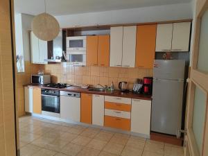 a kitchen with orange and white cabinets and appliances at Karla in Sveta Nedelja
