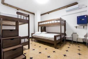 a bedroom with two bunk beds and a tv at Dream Hostel Odessa in Odesa