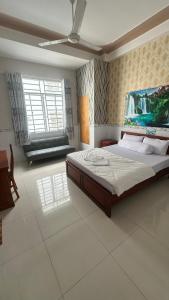a bedroom with a bed and a painting on the wall at Khách sạn Nhất Phương 2 in Ấp Ðông An (1)